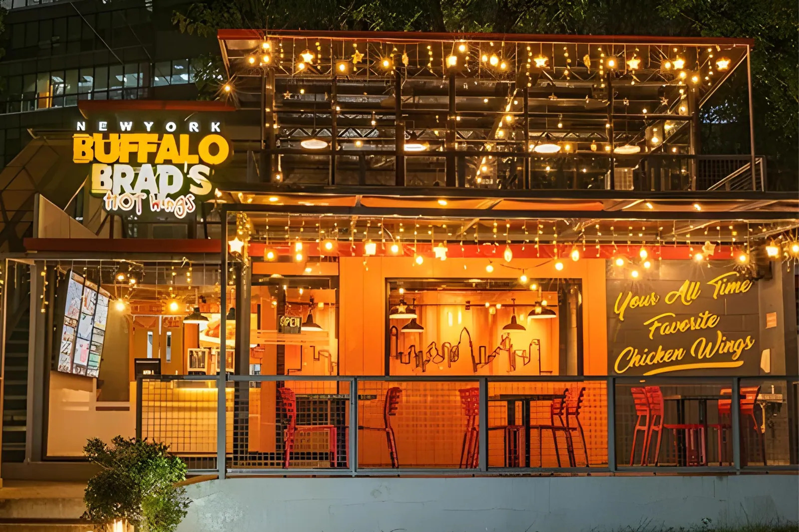 An NYBB Hot Wings branch at dusk, lit with string lights